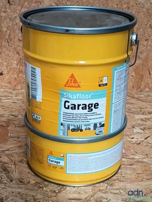 un bidon jaune de peinture de garage posé sur un plancher en bois
