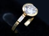 a close up of a diamond ring on a black surface