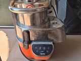 un mixeur orange et noir posé sur une étagère à côté d'un sac noir