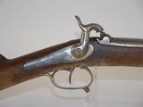 a close up of a gun with a wooden handle on a white surface