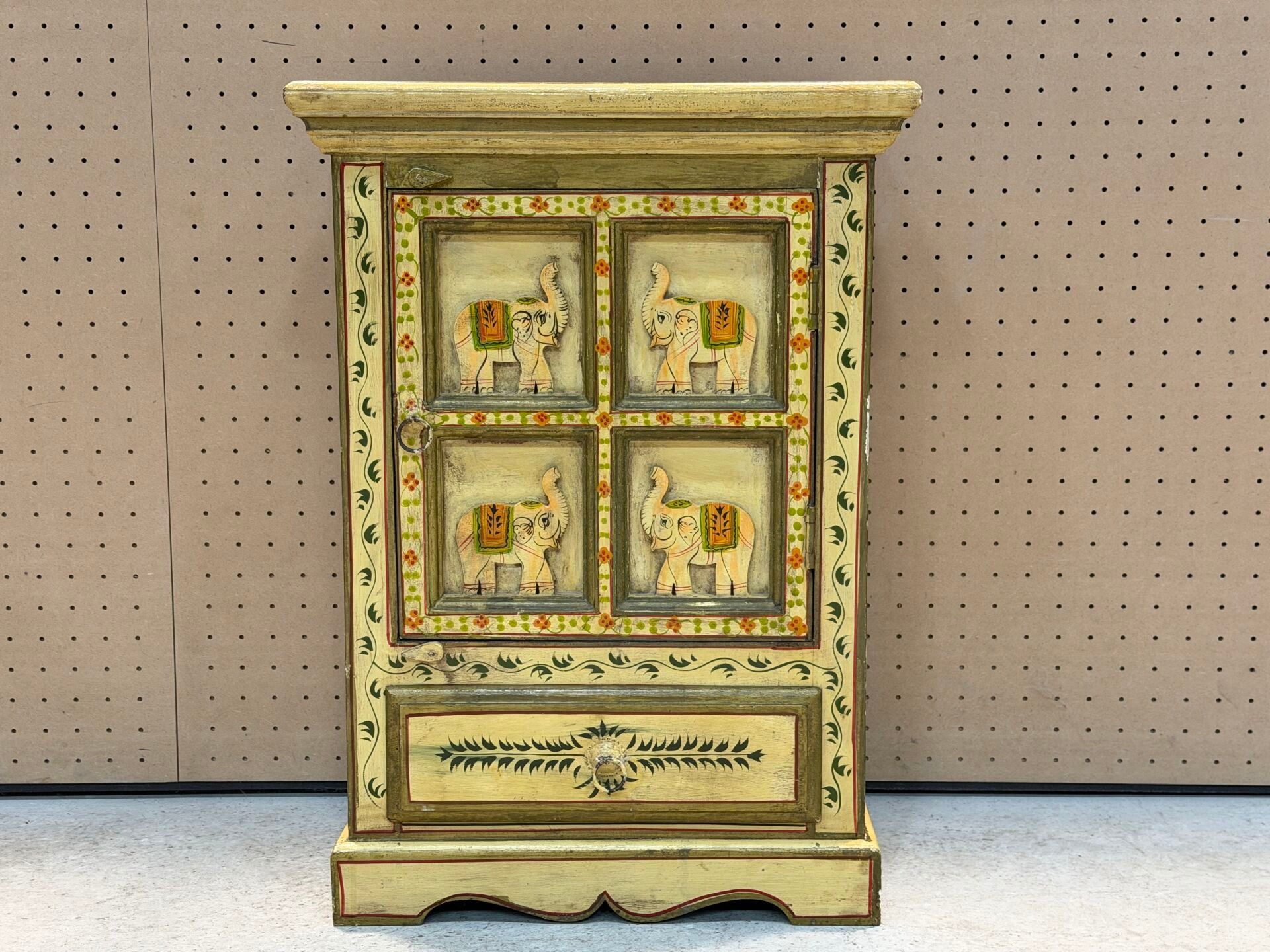 Petit meuble d'appoint en bois à décor d'éléphants.