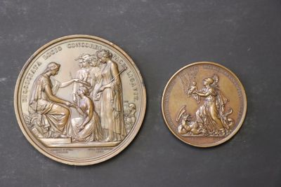 two gold medallions depicting the birth of jesus and the birth of mary