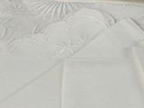 a close up of a white table cloth with a design on it