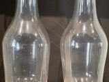 deux vases en verre posés l'un à côté de l'autre sur une étagère