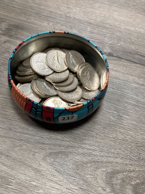 un bol rempli de pièces de monnaie posé sur une table en bois