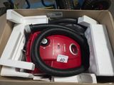 une boîte contenant un aspirateur et un tuyau