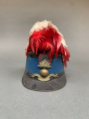 un petit chapeau orné d'une plume rouge sur le dessus