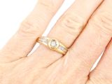 a woman ' s hand with a diamond ring on it