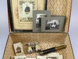 an open suitcase with pictures and a pen in it
