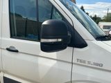 a white van parked in a parking lot with other vehicles