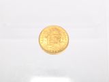 a close up of a gold coin on a white surface