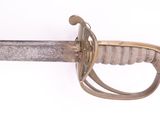 a close up of a sword on a white surface