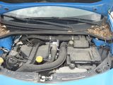 a blue car with its hood open and the engine in the trunk