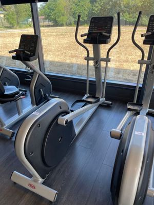 deux vélos d'appartement dans une salle de sport donnant sur un champ