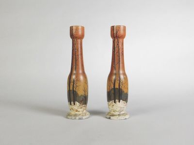 pair of vases on a white background with trees in the background