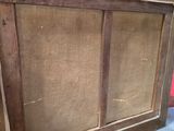 an old wooden cabinet with a glass door on top of it