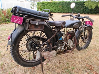 a old motorcycle that is parked in the grass