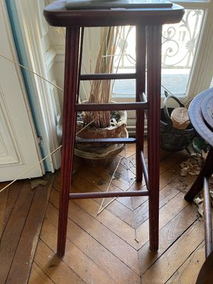 un chat assis sur un tabouret dans une pièce