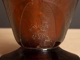 a brown vase with a black base sitting on a table