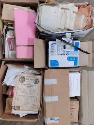 une boîte remplie de boîtes et de papiers posée par terre