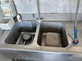 two sinks in the kitchen with a faucet on the counter