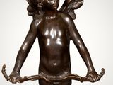 an image of a bronze statue of a cupid holding a bow