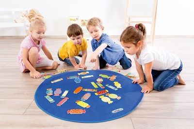 four children sitting on the floor playing with puzzles