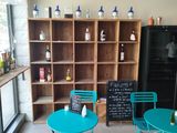 tables and chairs in a room with a bookcase and a chalk board