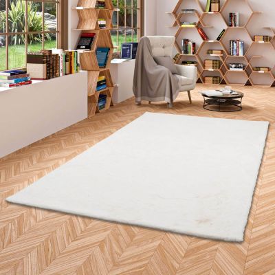 un tapis blanc au milieu d'une pièce avec des bibliothèques