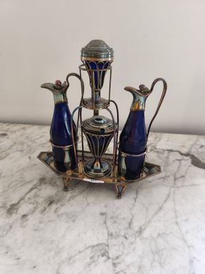 trois vases bleus et un plateau en argent posés sur une table en marbre