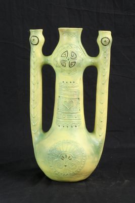 un vase vert posé sur un fond noir