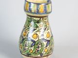 a small vase with a bird on it on a table