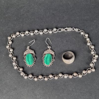 un gros plan d'un collier, d'un bracelet et d'une bague posés sur une table