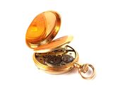 a gold pocket watch with a gold chain on it