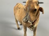 a small toy cow that is standing on a white surface