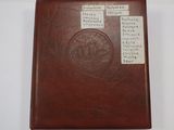 brown leather book with writing on it sitting on a white surface