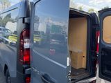 the back of a van with the door open is parked in a parking lot