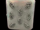 an image of a silver cigarette case with a number of symbols on it