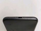 the back of a black cell phone sitting on top of a white table