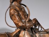 bronze statue of a man on a horse with a hat on
