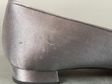 silver shoes on a table with a white wall in the background