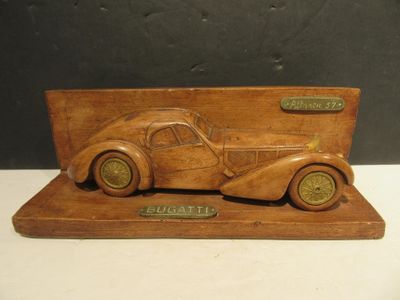 an antique wooden model of a car on display on a table