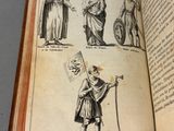 someone is holding an open book with a drawing of a man holding a staff