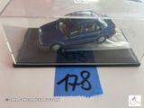 une petite voiture bleue dans une vitrine posée sur une table