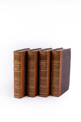 three old books sitting on top of each other on a white surface