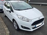 une Ford Fiesta blanche garée devant un immeuble