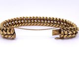 a gold bracelet with a chain and clasp on a white background
