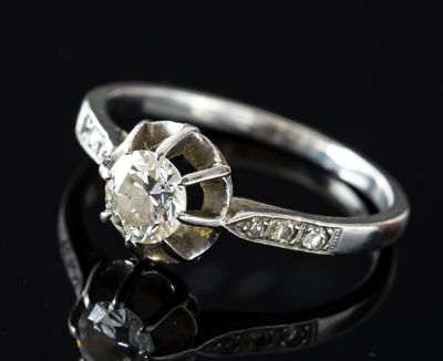 a close up of a diamond ring on a black surface