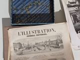 a blue bag sitting on top of a table next to a newspaper