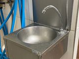 un évier en inox avec un tuyau bleu à côté